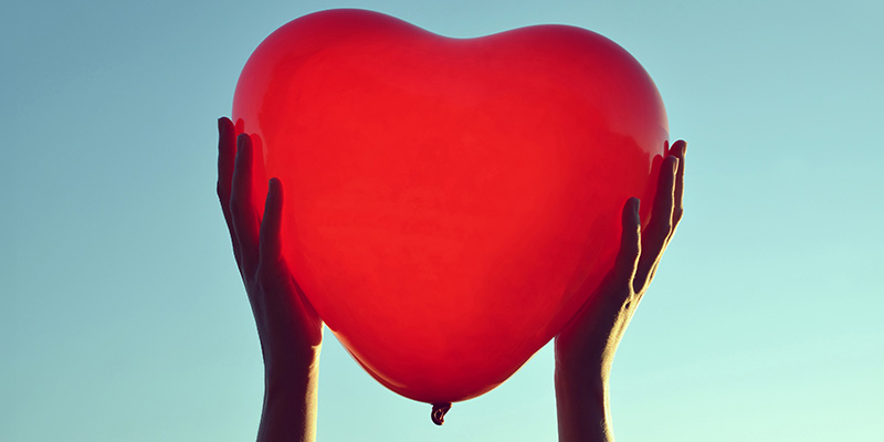 Hands holding a heart balloon